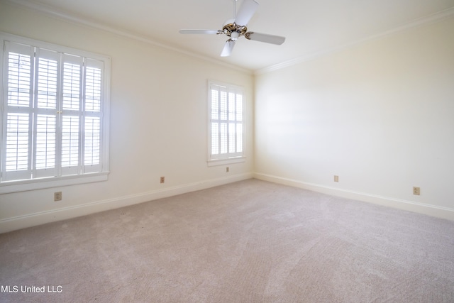 carpeted spare room featuring crown molding, ceiling fan, and a wealth of natural light