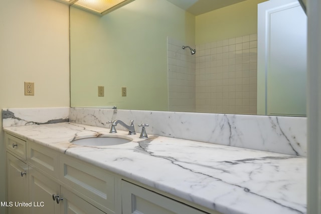 bathroom with vanity and a tile shower