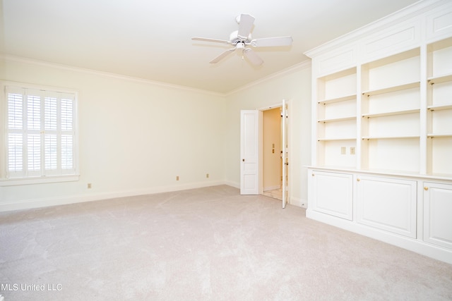 unfurnished room with crown molding, light carpet, baseboards, and ceiling fan