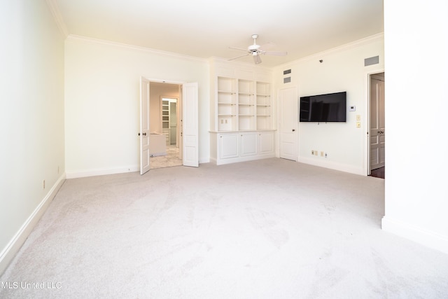 unfurnished living room featuring a ceiling fan, ornamental molding, built in features, and light colored carpet