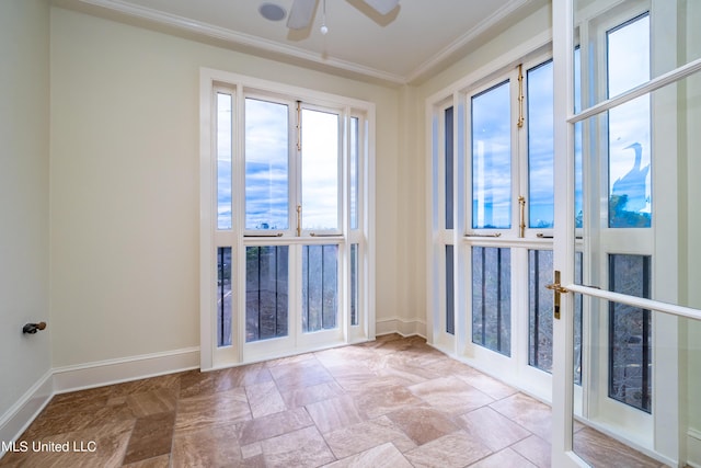 unfurnished room with french doors, a ceiling fan, stone finish floor, crown molding, and baseboards