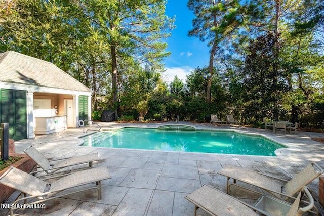 pool with a patio and an outdoor structure