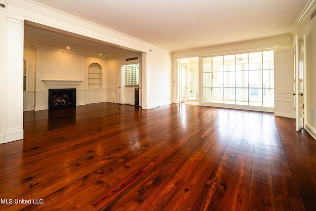 unfurnished living room with ornamental molding, dark wood finished floors, visible vents, built in shelves, and a fireplace