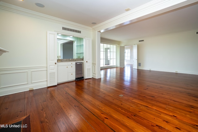 unfurnished living room with hardwood / wood-style flooring and ornamental molding