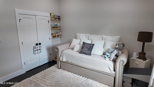 bedroom with dark wood-type flooring and a closet