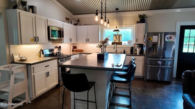 kitchen with appliances with stainless steel finishes, backsplash, a kitchen breakfast bar, decorative light fixtures, and white cabinets