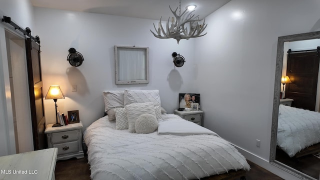 bedroom with a barn door and a chandelier