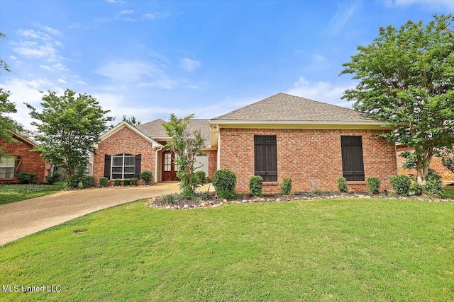 ranch-style home featuring roof with shingles, driveway, brick siding, and a front yard