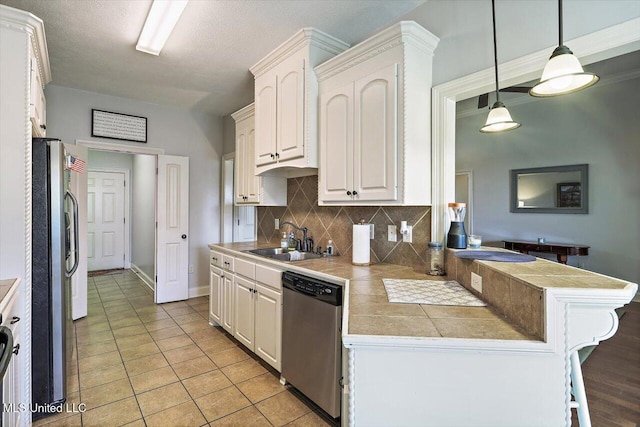 kitchen featuring a sink, appliances with stainless steel finishes, white cabinets, and backsplash