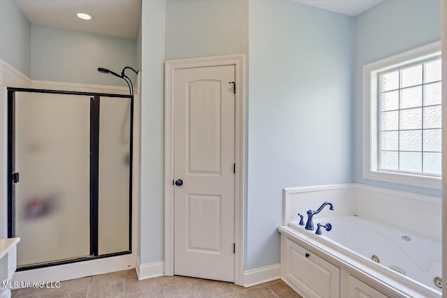 bathroom featuring plenty of natural light, baseboards, a stall shower, and a tub with jets