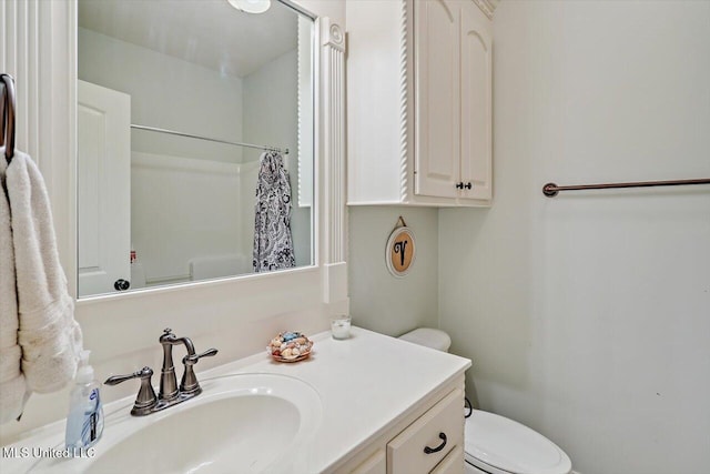bathroom with vanity, a shower with shower curtain, and toilet