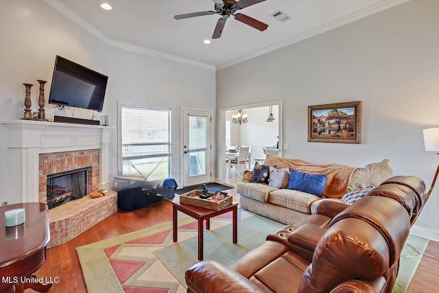 living room featuring ceiling fan with notable chandelier, recessed lighting, wood finished floors, and visible vents