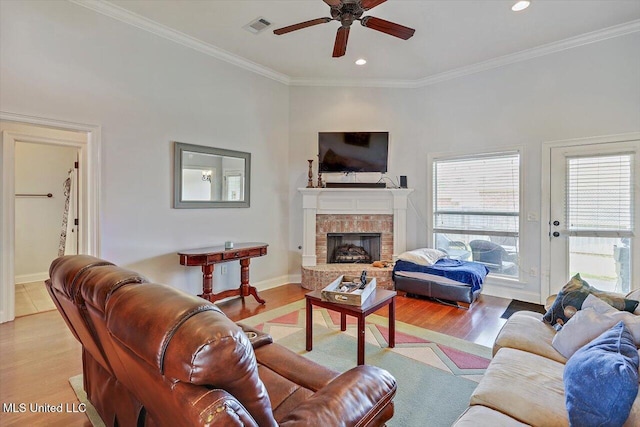 living area with crown molding, a ceiling fan, visible vents, and plenty of natural light