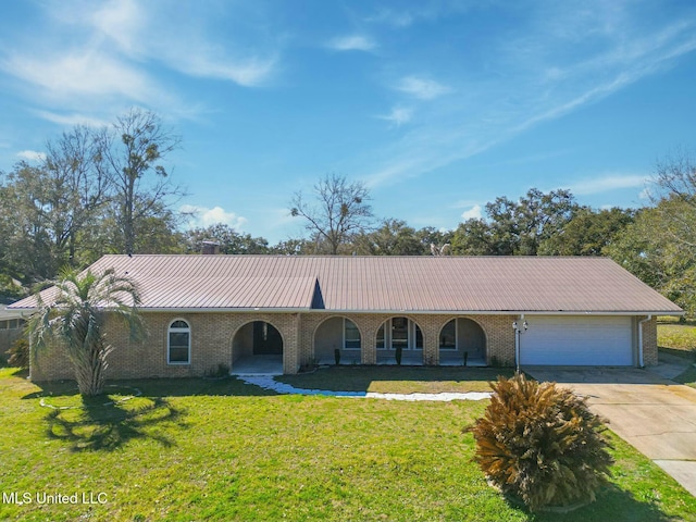 single story home featuring metal roof, an attached garage, brick siding, concrete driveway, and a front yard