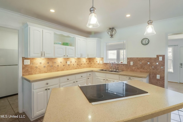 kitchen with black electric stovetop, open shelves, white cabinets, white dishwasher, and a sink