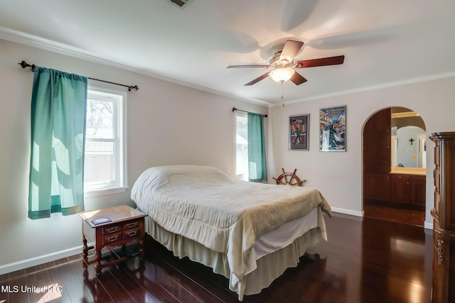 bedroom featuring baseboards, dark wood finished floors, arched walkways, and ornamental molding