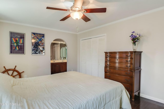 bedroom with crown molding, arched walkways, and a closet