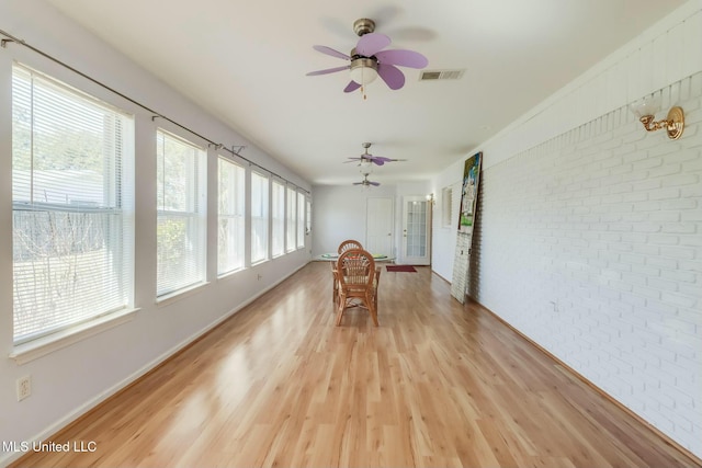 unfurnished sunroom featuring visible vents and a ceiling fan