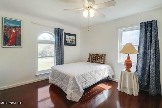 bedroom featuring multiple windows, wood finished floors, and baseboards