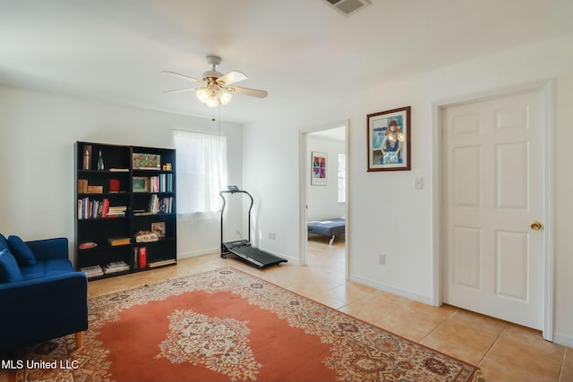 workout area featuring baseboards, tile patterned flooring, visible vents, and a ceiling fan