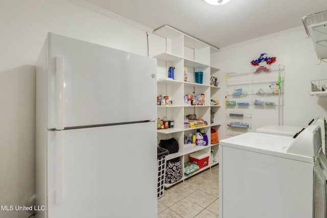 laundry room with light tile patterned floors, laundry area, crown molding, and washer and dryer