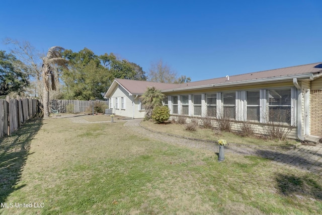 view of yard featuring central AC and fence