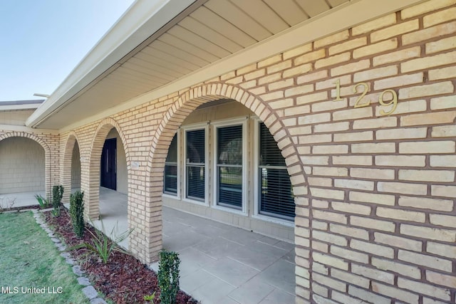 view of exterior entry featuring brick siding