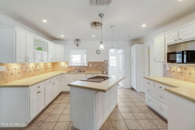 kitchen featuring light countertops, visible vents, white cabinets, a sink, and black appliances