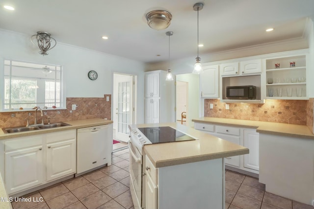 kitchen with crown molding, white cabinets, a kitchen island, a sink, and white appliances