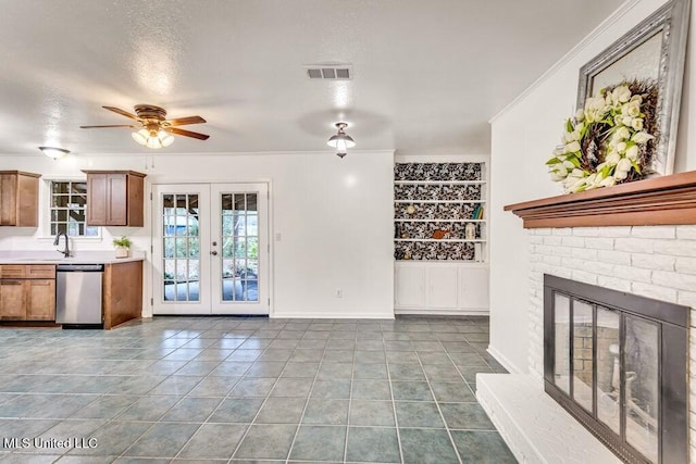 unfurnished living room featuring french doors, tile patterned floors, a brick fireplace, ornamental molding, and ceiling fan