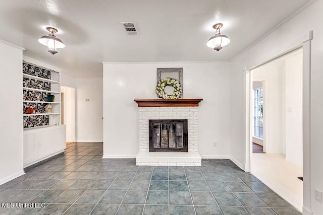 unfurnished living room with crown molding, a brick fireplace, dark tile patterned flooring, and built in shelves