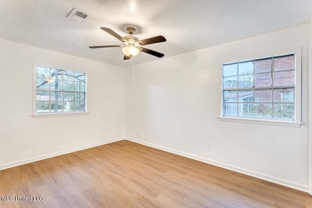 spare room with plenty of natural light, ceiling fan, and light hardwood / wood-style flooring