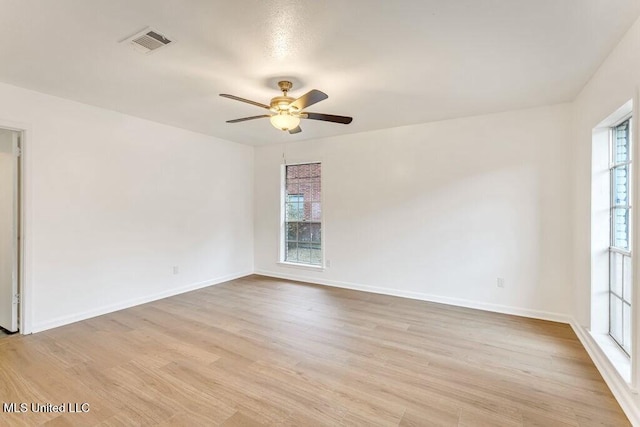 empty room with ceiling fan and light hardwood / wood-style flooring