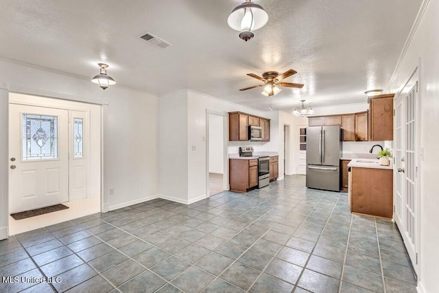 kitchen featuring ceiling fan, stainless steel appliances, a textured ceiling, and light tile patterned floors