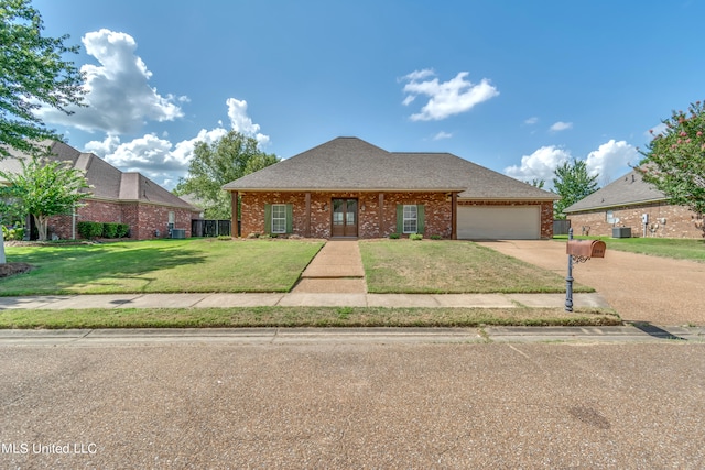 view of front of property with a front yard, a garage, and central air condition unit