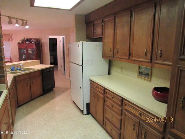 kitchen with white refrigerator, track lighting, black dishwasher, and sink