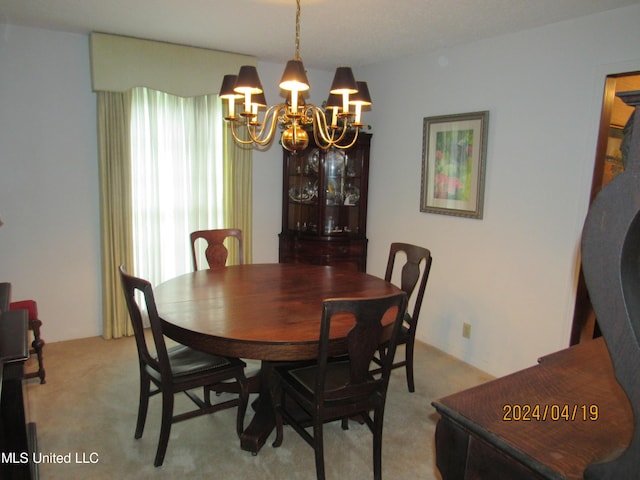 carpeted dining room featuring an inviting chandelier