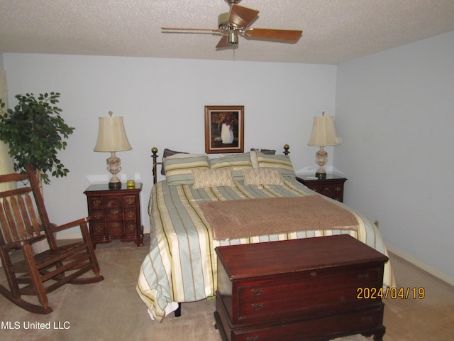 bedroom featuring a textured ceiling, ceiling fan, and light carpet