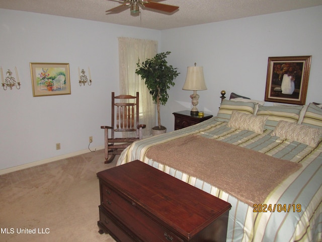 bedroom with ceiling fan, light carpet, and a textured ceiling