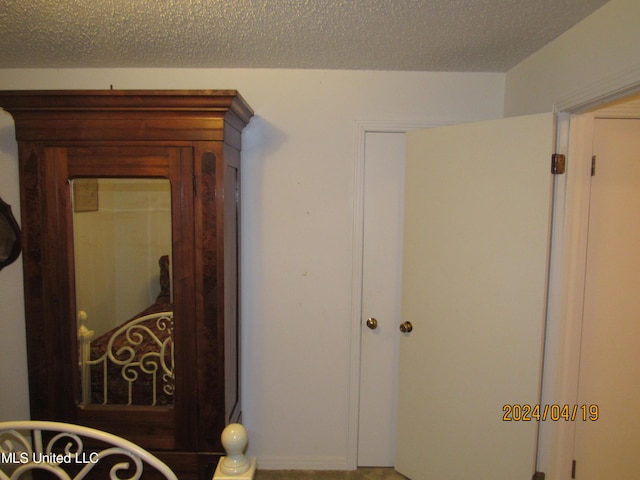 hall featuring a textured ceiling