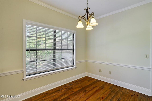 spare room featuring dark wood finished floors, an inviting chandelier, ornamental molding, and baseboards