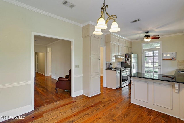 kitchen with under cabinet range hood, wood finished floors, visible vents, and stainless steel appliances