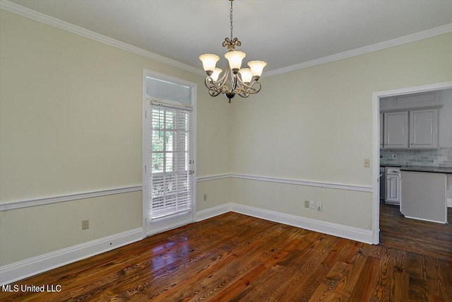 empty room featuring dark wood finished floors, baseboards, ornamental molding, and a chandelier