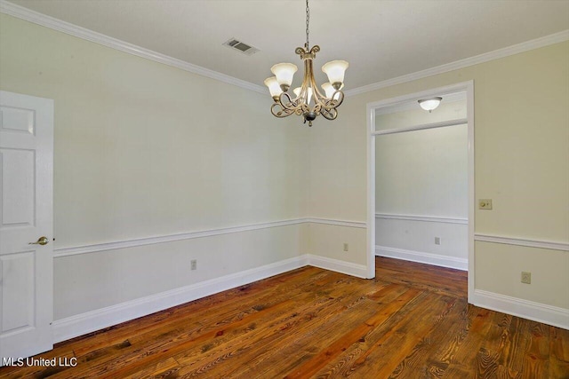 spare room featuring an inviting chandelier, wood finished floors, visible vents, crown molding, and baseboards