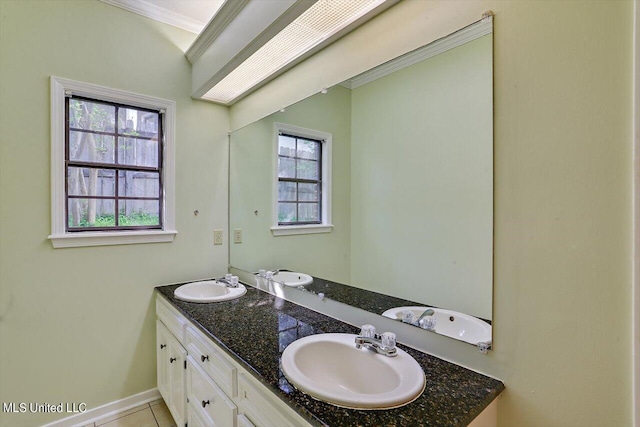 full bath featuring double vanity, baseboards, ornamental molding, and a sink