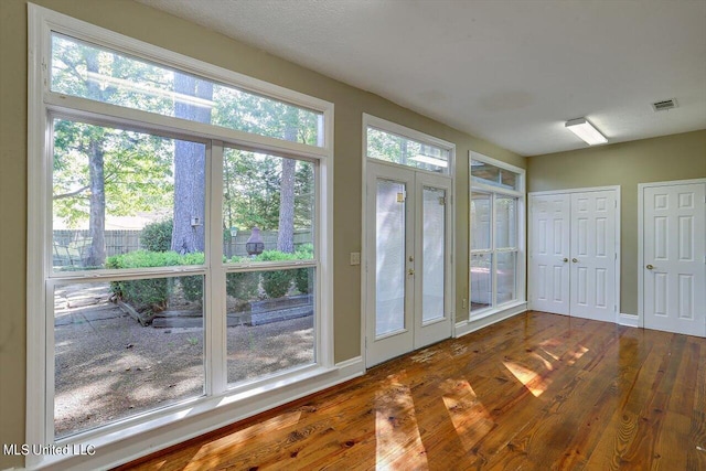 unfurnished sunroom featuring visible vents and french doors