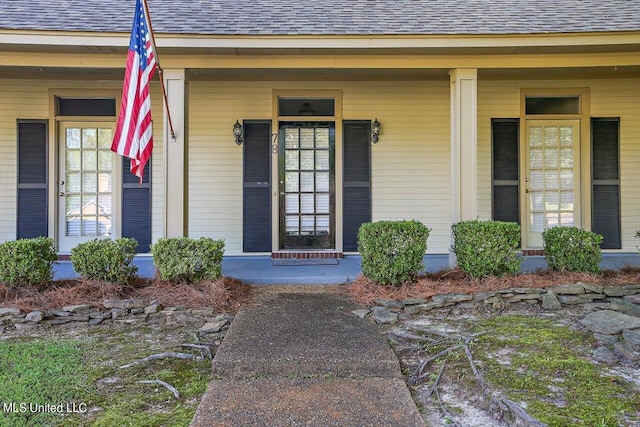doorway to property with roof with shingles and covered porch