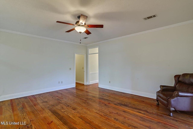 empty room with visible vents, ornamental molding, baseboards, hardwood / wood-style flooring, and ceiling fan