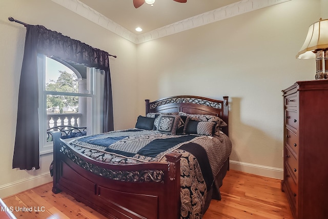 bedroom featuring ceiling fan, ornamental molding, and light hardwood / wood-style flooring