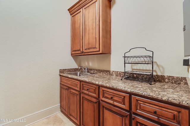 interior space with dark stone countertops and sink